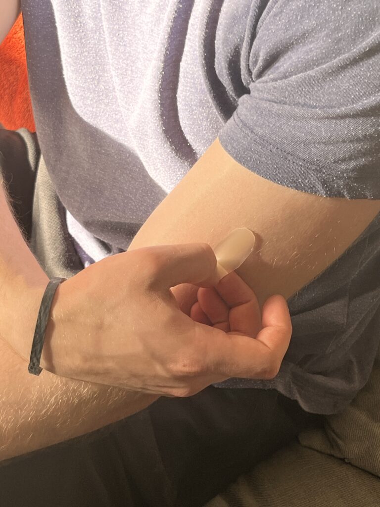 A gentle microneedle patch is placed on the upper arm. It is designed to be simple and comfortable to use.